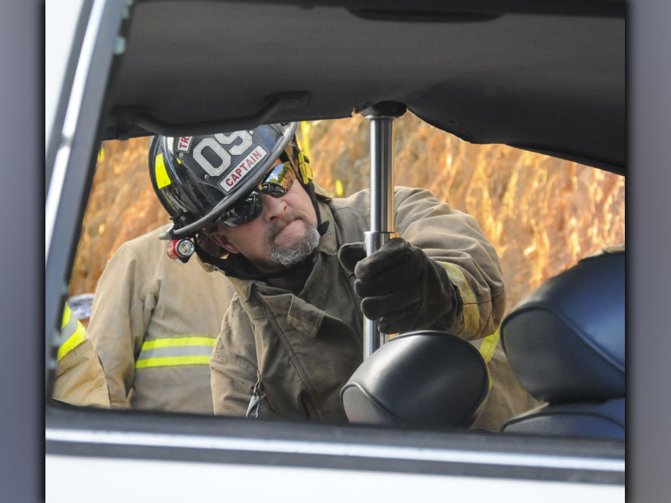 Fannin County Firefighter John Calvert uses a Hurst Ram to raise a roof on a wrecked car. This was one of the tools Fannin firefighters trained with during a refresher course on extricating patients from vehicles last week. Watching the effort is Fannin County Assistant Fire Chief Rob Ross.