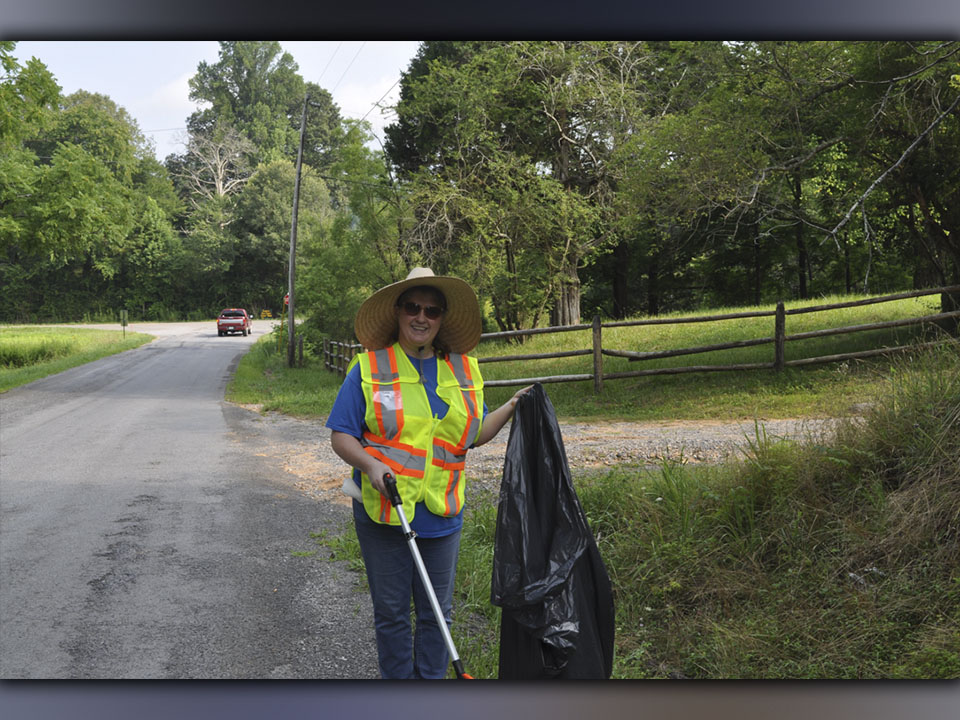 Dee Dee Deal helps to clean up trash along Reunion Road in Turtletown Saturday, July 24. 