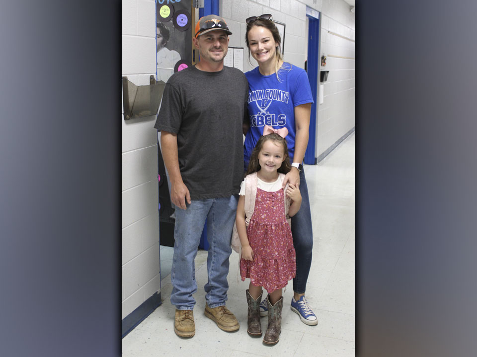 East Fannin Elementary School student Oakleigh Helton poses with her father and mother, Daniel and Heather Helton, as they drop her off for her first day of Kindergarten. 