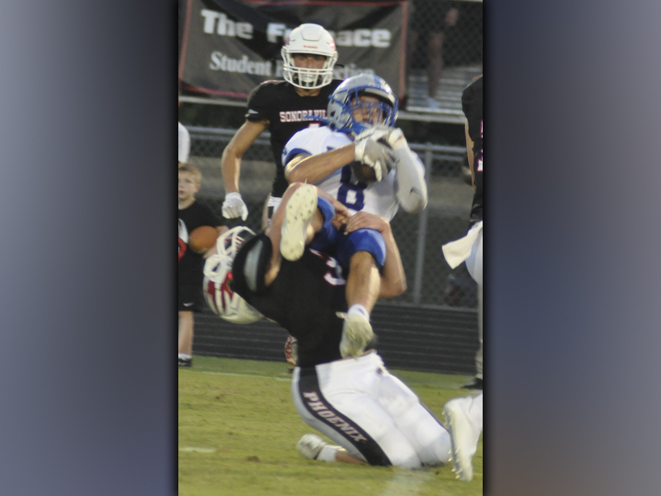 Logan Long (77) muscles his way past a lineman to put pressure on the quarterback during the Rebels game against Sonoraville Friday, September 3.