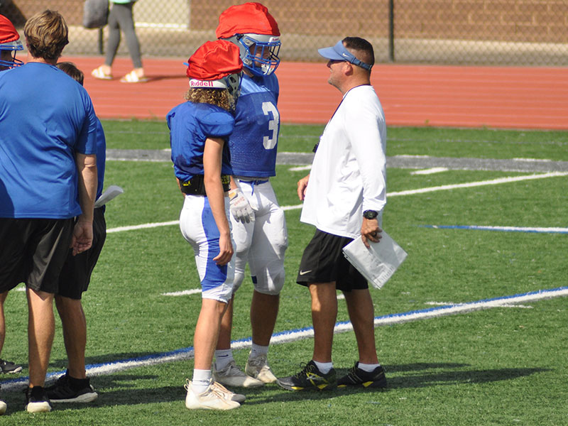 The Fannin County Rebels have been working all summer to prepare for the 2022 season. Head Coach Chad Cheatham, right, assists Elijah Weaver, left, and Case Holloway at practice Wednesday, July 27. The Rebels will scrimmage Stephens County at 7:30 at the Fannin County High School Stadium. 