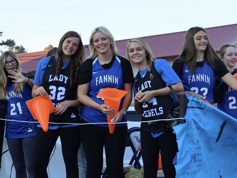 Hallee Walton, Macy Hawkins, Emma Holloway, Riley Reeves, Reese Lewis and Emma Buchanan smile and throw out candy from the Lady Rebels’ Basketball float in the Paint the Town Blue Homecoming Parade through downtown Blue Ridge Tuesday, October 11.