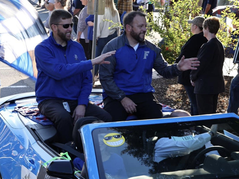 Superintendent Dr. Michael Gwatney and Fannin County High School Princpal Dr. Scott Ramsey wave to bystanders at the Paint the Town Blue Homecoming Parade through downtown Blue Ridge Tuesday, October 11.