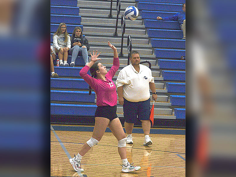 Libero Maddie Pelfrey (13) watches the ball before her serve during the playoff match this past week.