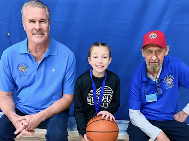 Jack Devine and Gerald Renny are shown with Molly Prince, the 11-year-old girls free throw winner.