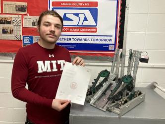 Fannin County High School senior John Moler is shown with his acceptance letter from the Massachusetts Institute of Technology (MIT) and a robot he and Luke Pelfrey engineered.