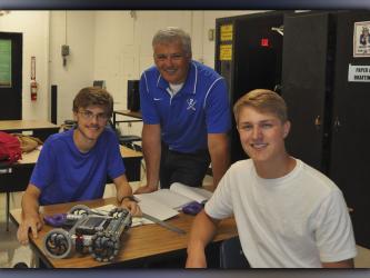 Engineering II students James Kyle, left, and Bryce Ware show off their completed robot to their teacher Bubba Gibbs at Fannin County High School Friday, August 6. 