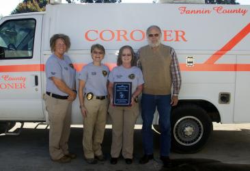 Fannin County Coroner Becky Callihan was honored by the Georgia Corners Association with the A.R. King Award, which recognizes outstanding public servants. Only one such award is presented each year. She is shown holding her plaque alongside deputy coroners Rebecca Hughson and Felicia Folds and her husband, Don Callihan.