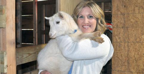 Jennifer Criteser is shown holding Bella Luna, one of many baby goats on the rescue farm she started after realizing how many animals need a good home.
