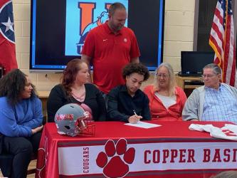 A.J. Fitchett is shown as he signs his letter of intent last week to play football for Union College in Barbourville, Kentucky. Shown during the ceremony are, from left, seated, Jadyn Fitchett, Jaclyn Miles, Fitchett, Susan Miles and Allen Miles; and standing, Copper Basin Head Football Coach Chad Grabowski.