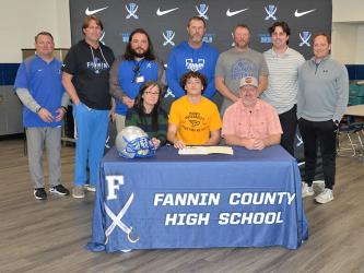 Brody Paskill (seated, center) signed his Letter of Intent Friday to play football at Point University. He is shown with his mother, Catrina McQuigg, and father, Eric McQuigg, and coaches, standing from left, head coach Chad Cheatham, Alan Collis, Jeremy King, Jeff Kuna, Chris Hyde, Jacob Reece and Wade Woodall.