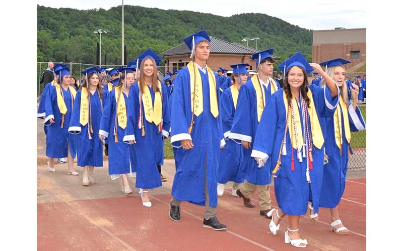 News Observer photo/Mollie Morrow - Fannin County High School graduates Eva McNelley, Hudson Lynch and Ryleigh Loudermilk, from left, first row, walk onto the field at Rebel Stadium for graduation Friday, May 22.