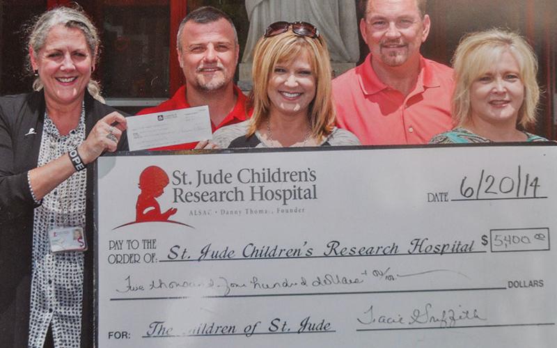 Tracie Griffith, center, holds a donation check in the amount of $5,400 to St. Jude Children’s Research Hospital. Standing with her are, from left, a St. Jude representative, husband Mark Griffith, CJ Green and Sherry Green.