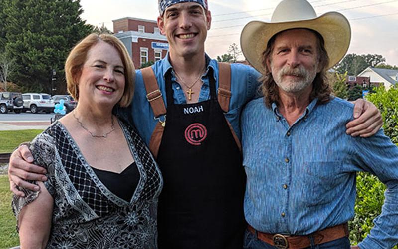Epworth native and MasterChef top four television show contestant Noah Sims hugs his mom, Ann, and his dad, Richard, during Noah Night, September 11. Community members gathered in the downtown Blue Ridge park to watch the MasterChef semi-finals on the big screen. Sims narrowly missed making it to the top 3 contestants.