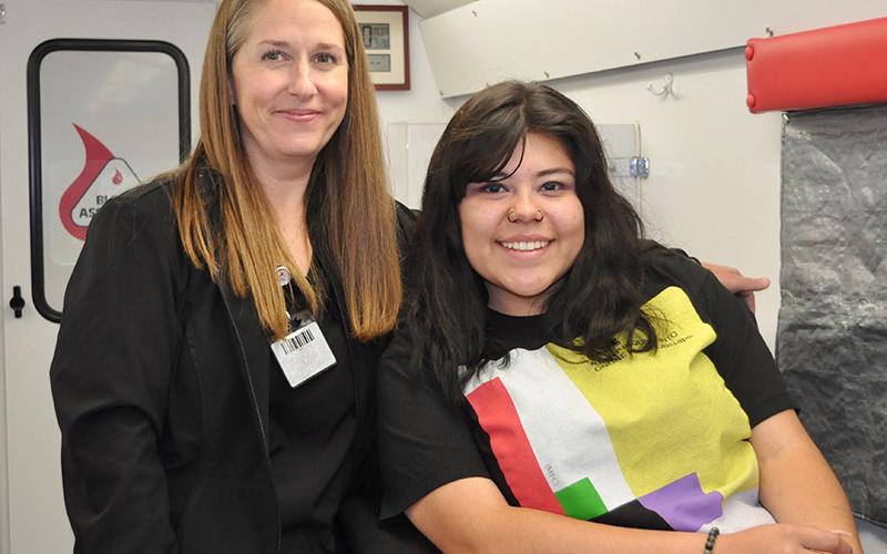 Blood Assurance’s Donor Care Specialist, Ava, assists Fannin County High School student Kristen Lopez before she donates blood.