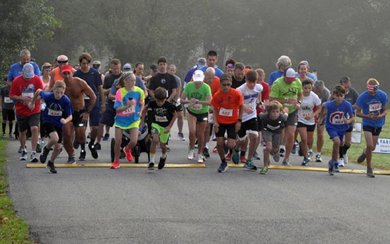 Runners pass the starting line at the Boys &amp; Girls Club of North Georgia Labor Day 5K River Run at Horseshoe Bend Park Saturday, August 31.