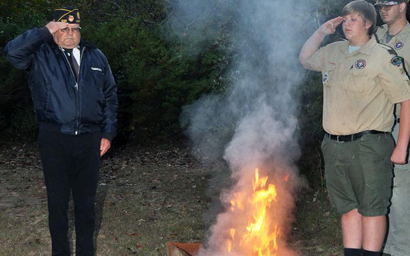 Members of local veterans organizations, the North Georgia Honor Guard and Boy Scout Troop 32, conducted a Flag Retirement ceremony at Ron Henry Horseshoe Bend Park Tuesday, October 22. Veteran Richard Crosley, left, and Boy Scout Ethan Jolly, right, salute an American flag as it is properly retired.
