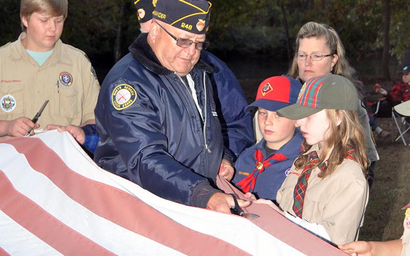Veteran Richard Crosley retires the stripes by cutting them off one by one during a Flag Retirement ceremony at Ron Henry Horseshoe Bend Park Tuesday, October 22. Members of local veterans organizations, the North Georgia Honor Guard and scouts conducted the patriotic ceremony.