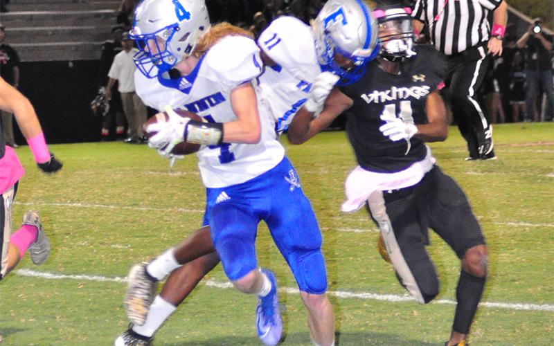 Fannin Rebel Andre Bivens (11) blocks a defender to keep the play alive as Cohutta Hyde (4) rushes down the field for a gain during the Rebels region win over East Hall Friday, October 11.