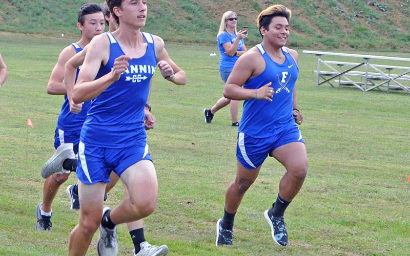 Fannin County Rebel cross country runners Jake Jones, left, and Hernan Mares, right, battle during a recent cross country meet.