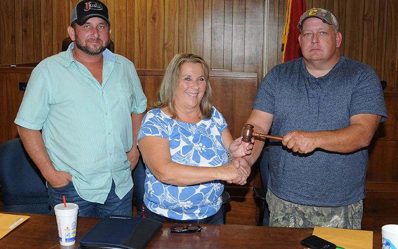 Debbie Davis, who represents District 1, was elected chairwoman of the Polk County Board of Commissioners Thursday, September 26. Here, she receives the gavel from outgoing Chairman Greg Brooks, right. Incoming Vice Chairman Jeremy Kimsey, who represents District 3, is at left.
