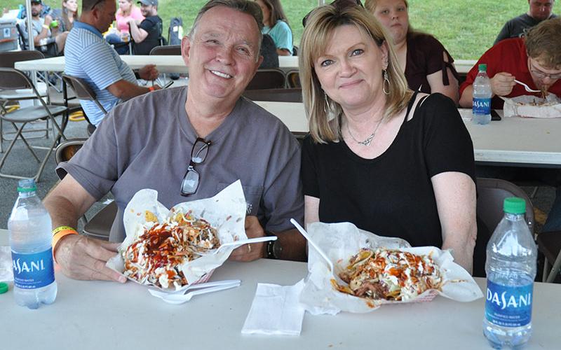 Mike and Ginger Epperson chow down on piles of barbeque nachos as blues music filters over the air during the Blues &amp; BBQ Festival.