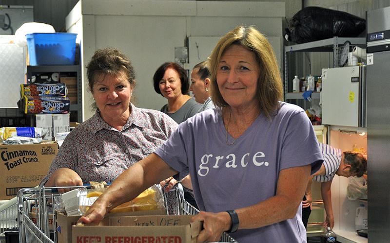 Family Connection food pantry volunteers Priscilla McDonald, left, and Meredith Yacavone work to unload and organize food in the new, larger food storage area at the organization’s new building at the end of Industral Road in Blue Ridge.