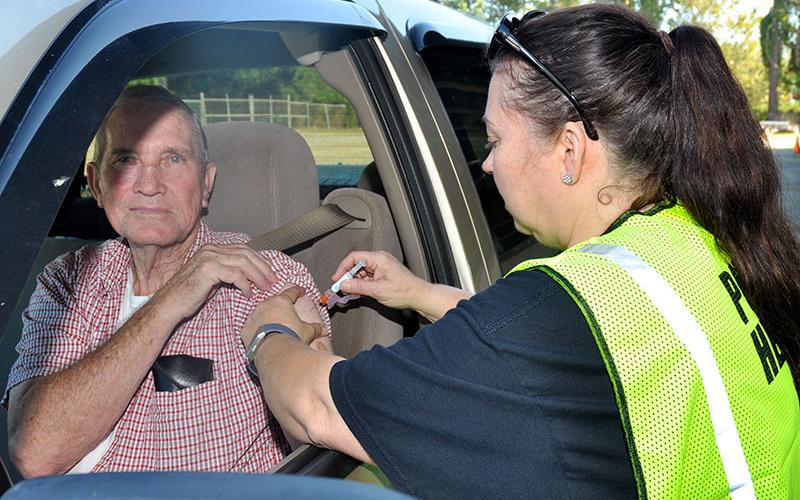 Clyde Ware lifts his sleeve to receive a flu shot given by Fannin County Health Department Nurse Elizabeth Thomas.