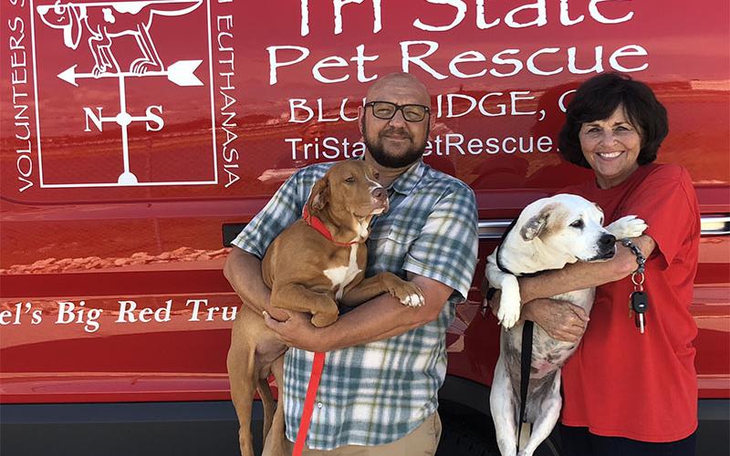 Rescue worker Gabe Waters holds Chester, pound puppy from a shelter in Alabama, while rescue volunteer Jan Eaton holds Dolly, a pup from Fannin County Animal Control. The pair of dogs were on a recent transport to Florida where they will be networked and adopted.