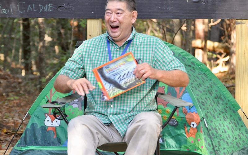 East Fannin Elementary School Media Specialist Gary Baxter read to students and their families at the new outdoor classroom during the school’s camping themed literacy night.