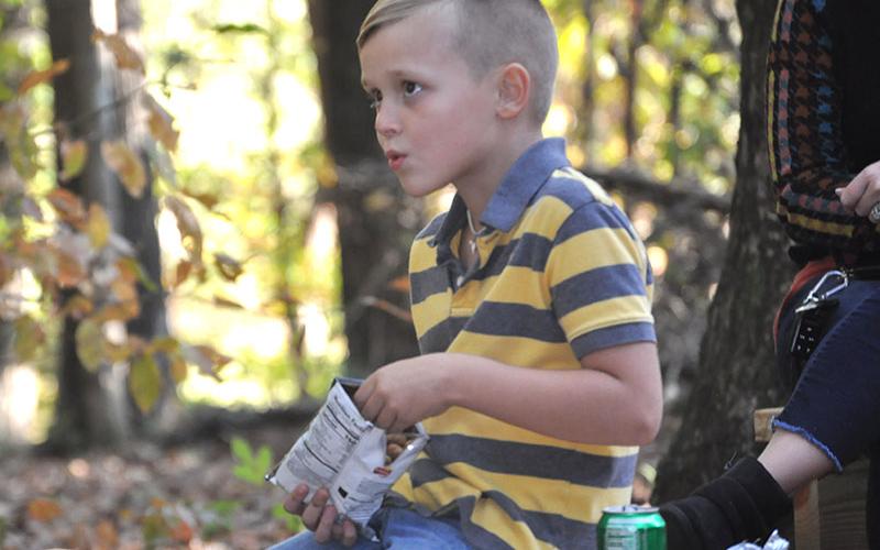 East Fannin Elementary School student Seth Owenby ate a campfire dinner while listening to a story in the school’s outdoor classroom.