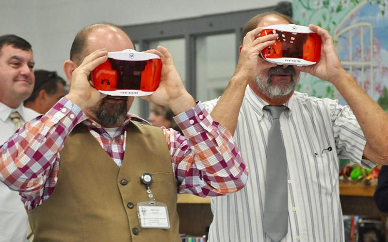 Fannin County Board of Education members Mike Cole, left, and Lewis Deweese try out recently purchased view masters in the Fannin County Middle School media center. FCMS was one of the stops on last week’s school board retreat.