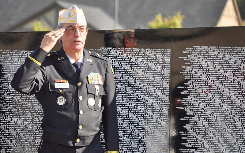 Veteran Manny Lozano salutes the American flag as the North Georgia Honor Guard posted the colors during the The Vietnam Traveling Memorial Wall memorial service.