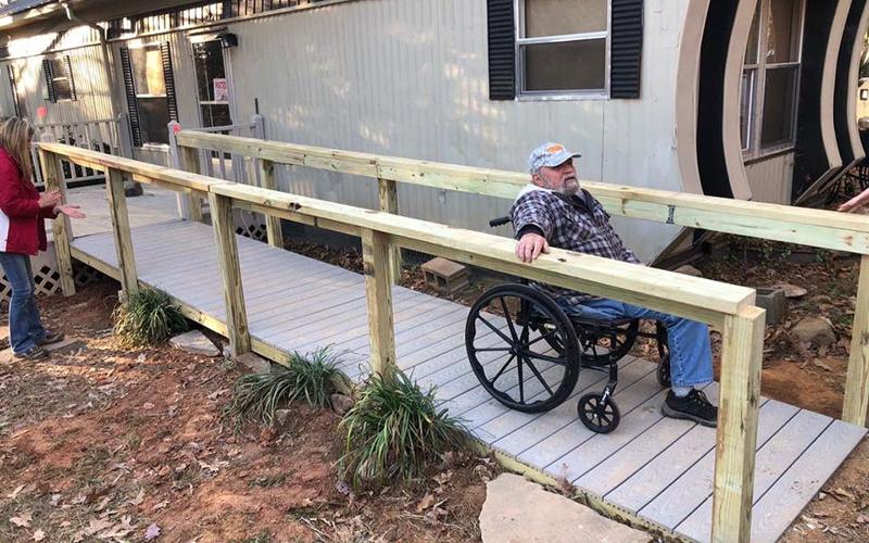 Roger Dionne puts his new wheelchair ramp to the test. The ramp was built using materials donated by Home Depot for the The Vietnam Traveling Memorial Wall that had been salvaged after the wall was taken down.