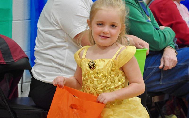Princess Belle, formerly known as Maggie Nazerian, fills up her bag with candy during East Fannin Elementary School’s trick-or-treating event.