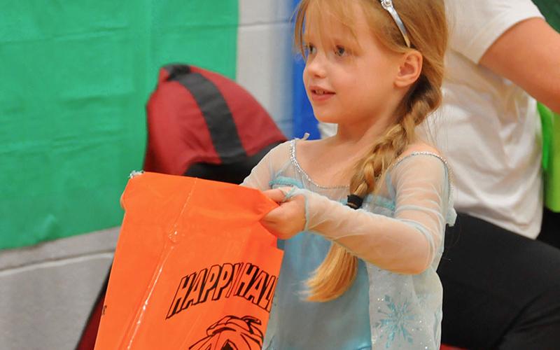 Kelsey Ray holds up her bag as she requests a treat at East Fannin Elementary School’s Halloween event.