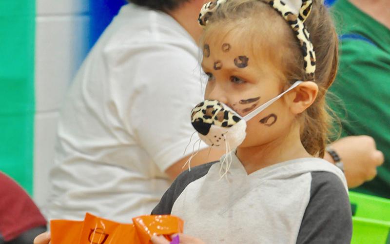 Viktorya-Zoe Lipscomb holds out her trick-or-treating bag to receive candy at East Fannin Elementary School.