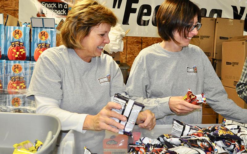 Snack in a Backpack volunteers Mary Langford, left, and Rose Schueneman helped the organization pack their 20,000th meal of the 2019-2020 school year Wednesday, November 20.