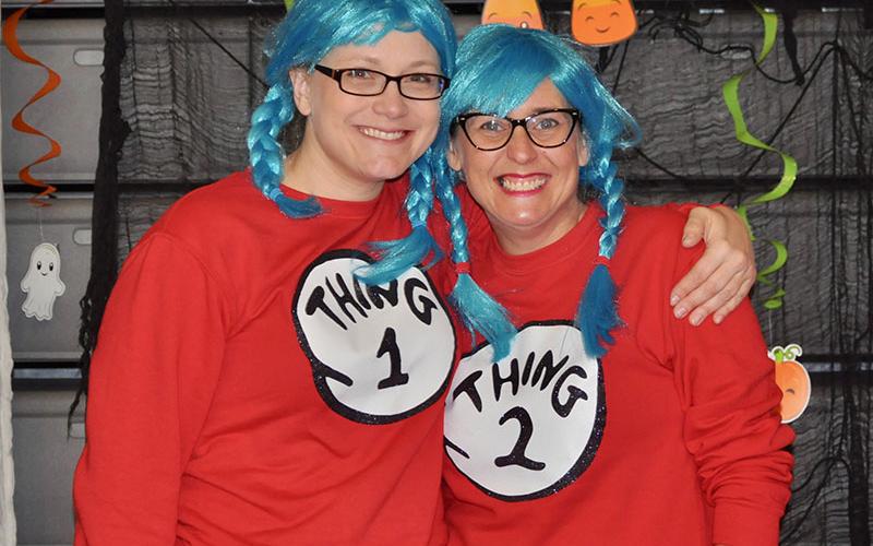 Thing 1 and Thing 2, also known as Brooke Owens, left, and Katie Turner, pass out Halloween candy to students at West Fannin Elementary School.