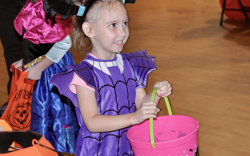 Annabella Perkins holds out her bucket for candy at West Fannin Elementary School.