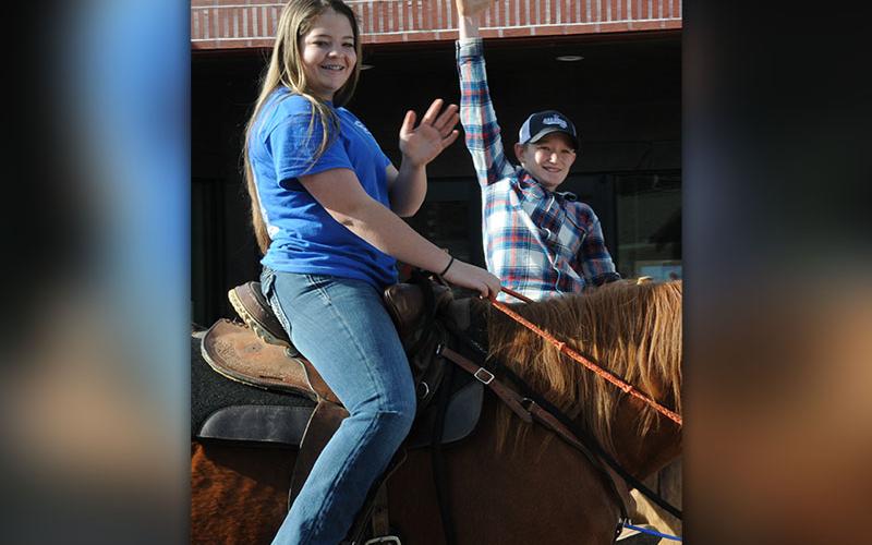 Two young riders wave to the crowd lining Blue Ridge Drive during the Copperhill Kiwanis Club Christmas Parade.