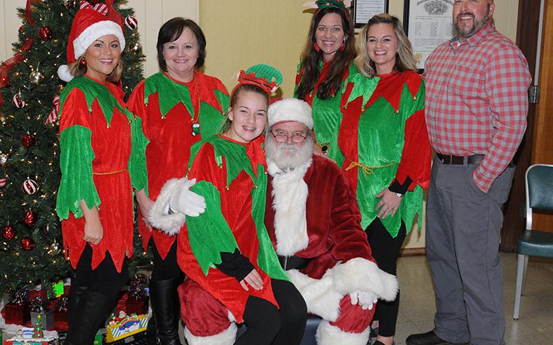 Santa Claus had plenty of help to pass out toys and play games with the children when he visited the Copper Basin Community Center in Ducktown Friday, December 13. The event, which provided free toys to the children was organized by Polk County Executive Robby Hatcher. Shown during a break are, from left, Heather Hill, Lois Potts, Zoie Hatcher, Santa, Catrice Lowe, Tina Hatcher and Robby Hatcher.