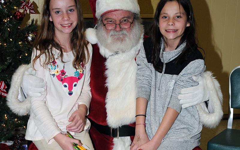 Sisters Alexis, left, and Alicia Green visited with Santa Claus at the Copper Basin Community Center. The event was organized by Polk County Executive Robby Hatcher.