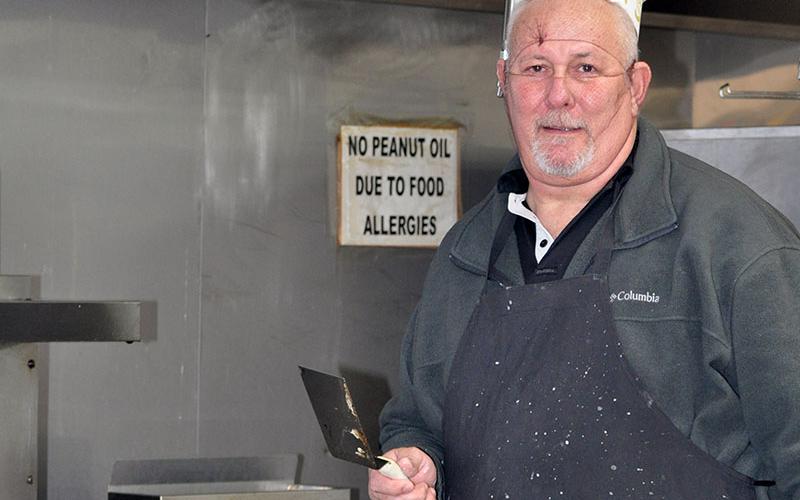 Family man Steve Shamblin dons hairnets and a chef’s hat as he cooks pancakes for hungry folks during a recent fundraiser to raise enough money to pay for the adoption of an orpahaned teenager from Columbia.