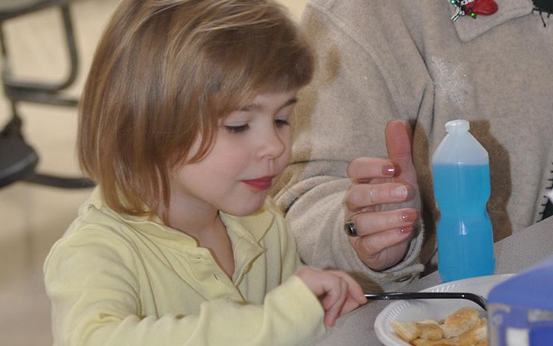Brittlyn Zeigler nibbled on a pancake breakfast freshly made by Mountain Area Christian Academy school adiministrator Steve Shamblin.