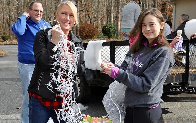 Amy, left, and Hannah Price smile while testing the icicles lights for the Fannin County Special Olympics Light Up Blue Ridge parade float Friday, November 29.