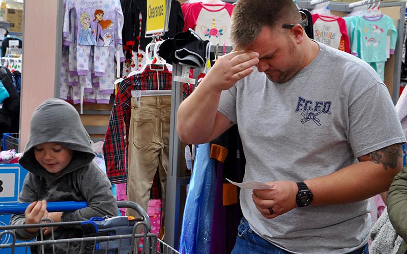 Fannin County Firefighter Tim Grant, right, jokingly checks out Leiland Hughes’ Christmas list to decide which item they should pick out next. The two were busy on their gift hunt during the Fannin County Sheriff Office’s annual Shop With a Cop Saturday, December 7. This year the event served over 80 children. Prior to going shopping, the children were treated to a meal and a visit  from Santa Claus.