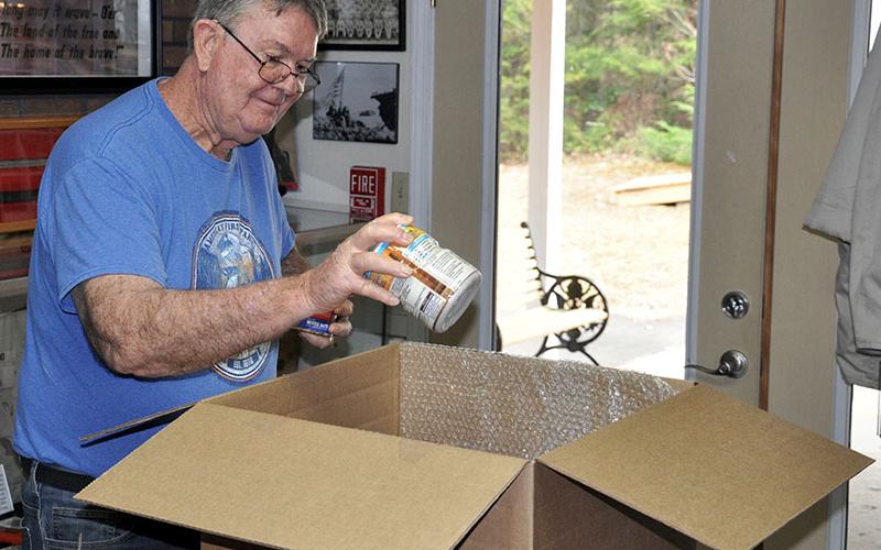 Local Veterans teamed up to send care packages to a group of U.S. troops in Afghanistan. Veteran Ken Campbell is shown filling a care package Monday, December 9.