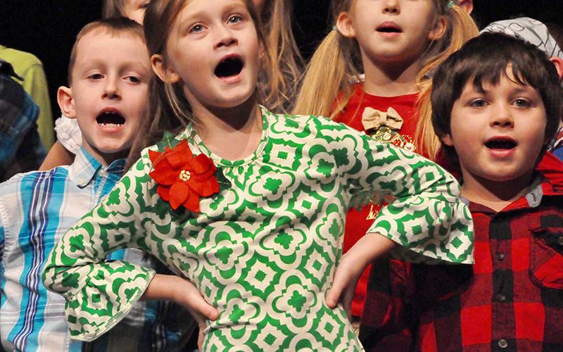 East Fannin Elementary School student Lily Eckels swayed back and forth to the beat of a Christmas song during the school’s White Christmas program. Shown behind her are Jake Dyer, left, and Camden Carver.