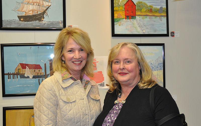 North Georgia Autism Foundation representative Cathy Ritchie and Jan Stahl, the mom of one of the artists who is displayed, chat as they view the art hanging on the walls of the Foundation’s new art gallery micro-buisness.